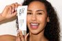 Woman holding a Cooling Body Scrub skincare with a plain background