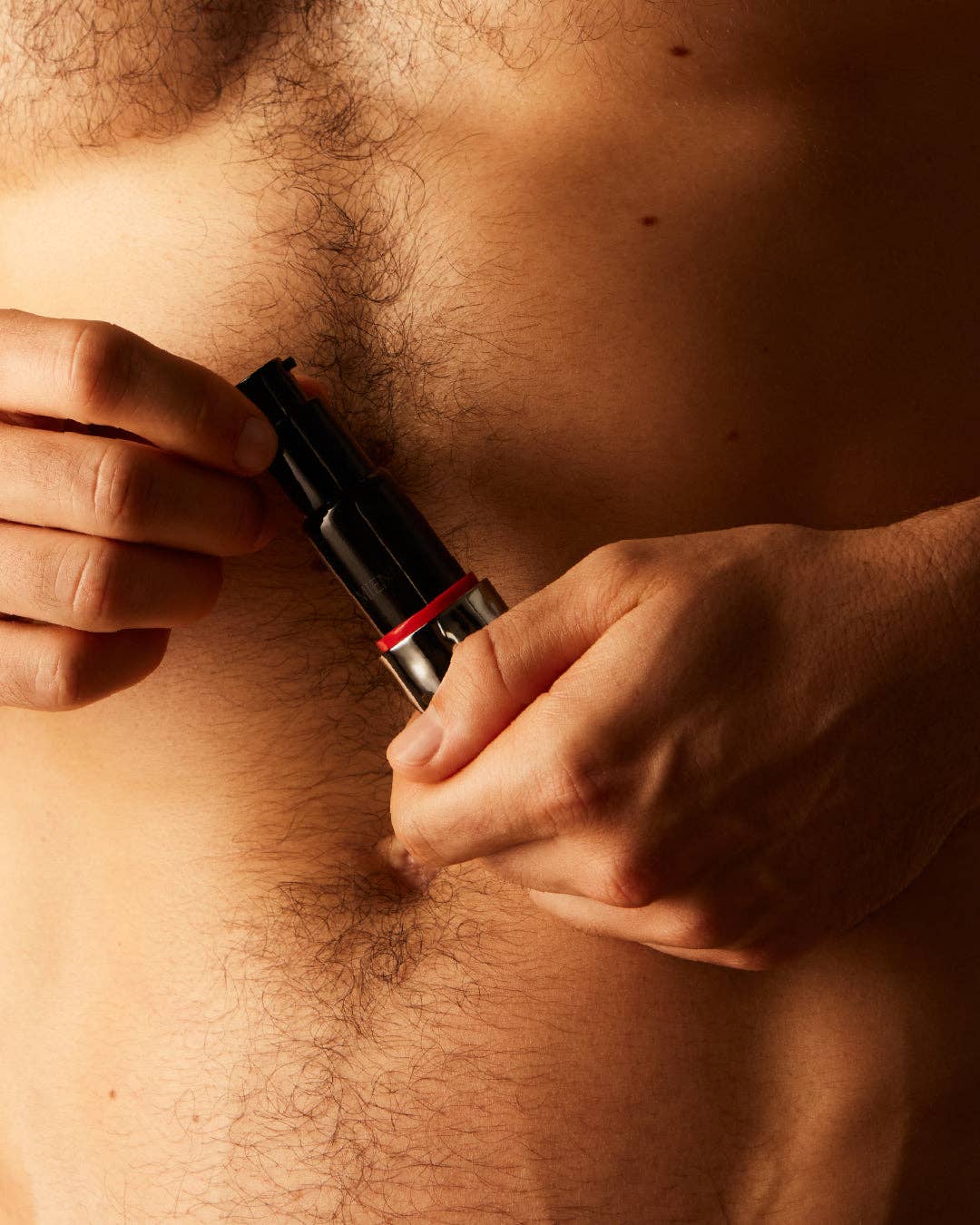Person holding a product in a silver package against their chest.