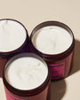 Three open jars of cream with visible brand name on a beige background