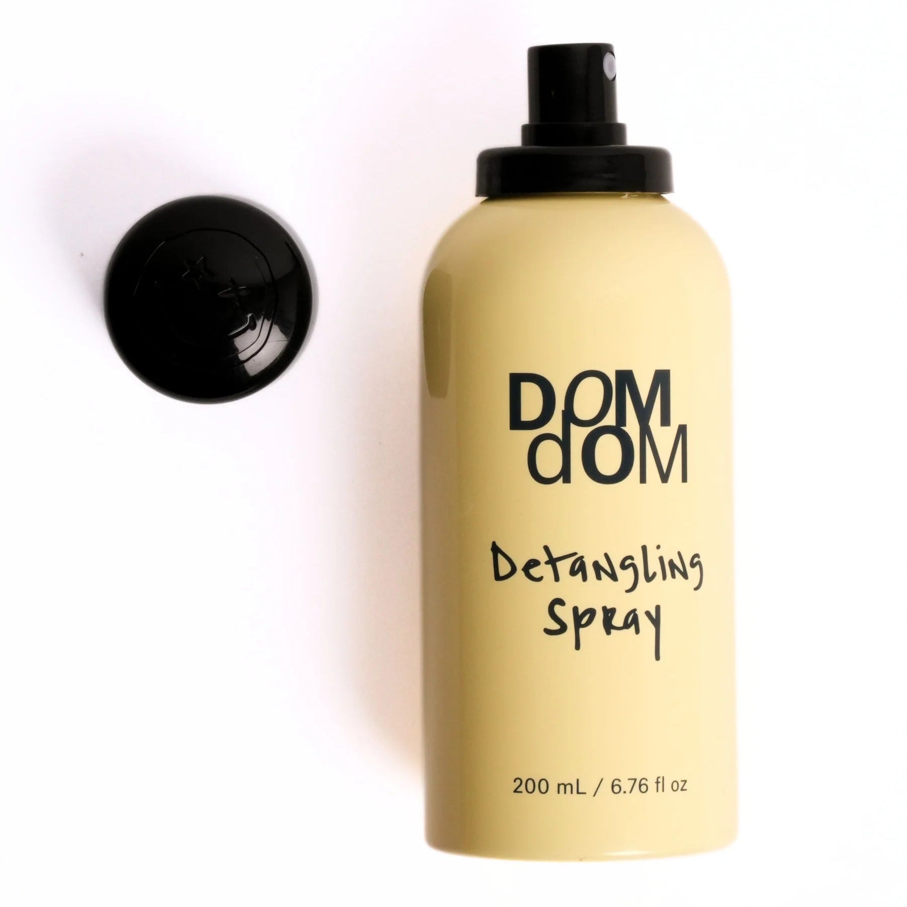 Detangling spray bottle labeled 'DOM DOM' on a white background