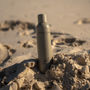 Dolce glow  bottle in the sand