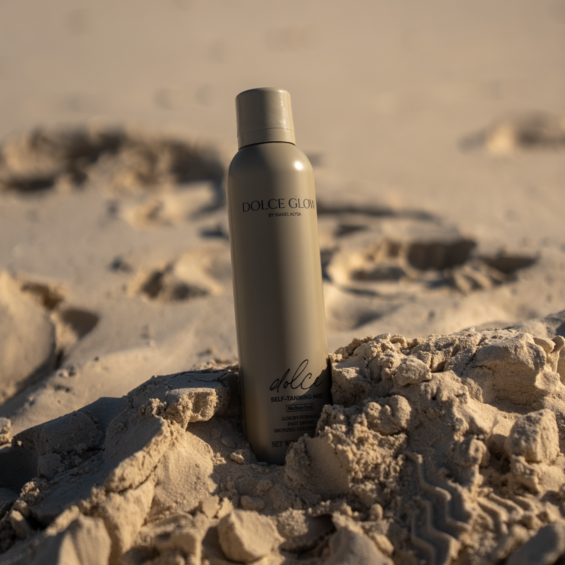 Dolce glow  bottle in the sand
