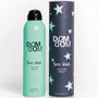 Green bottle and navy tube of DOM DOM Texture Spray on a white background