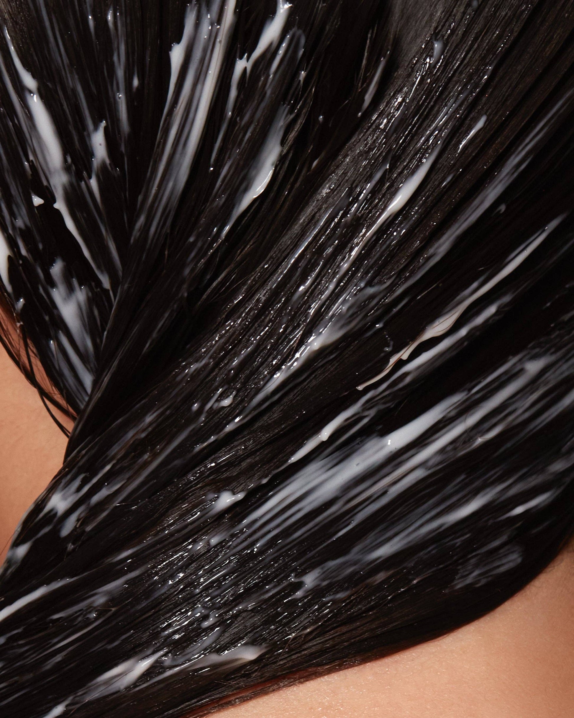 Close-up of black hair with hair mask on a person's head