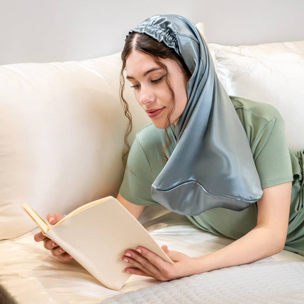 Woman reading a book on a couch with a satin blue bonnet