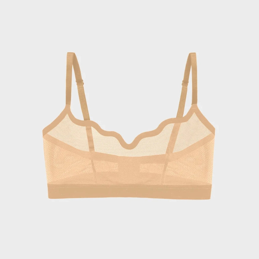 A sheer nude-beige mesh underwire bra with scalloped edges and adjustable shoulder straps, shown flat against a light gray background.