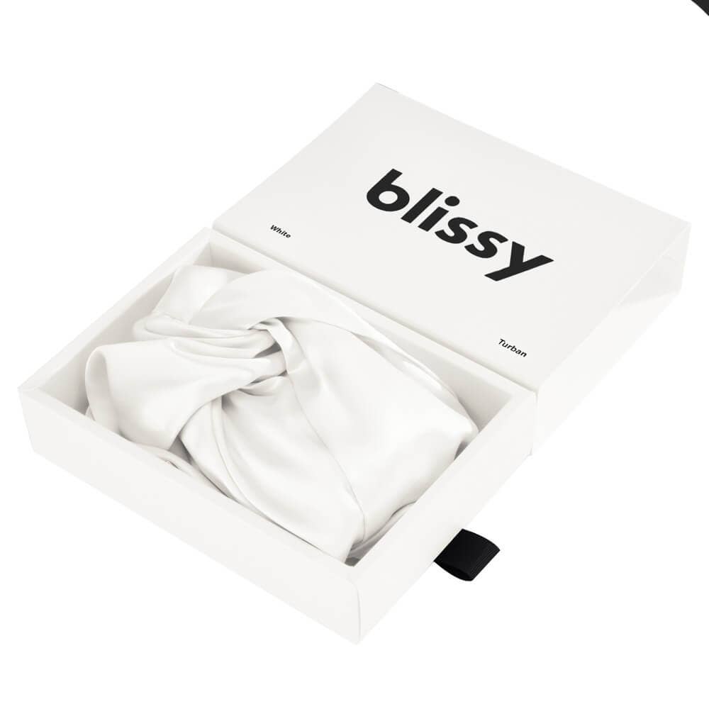 White satin bonnet in a box with 'blissy' branding on it on a white background