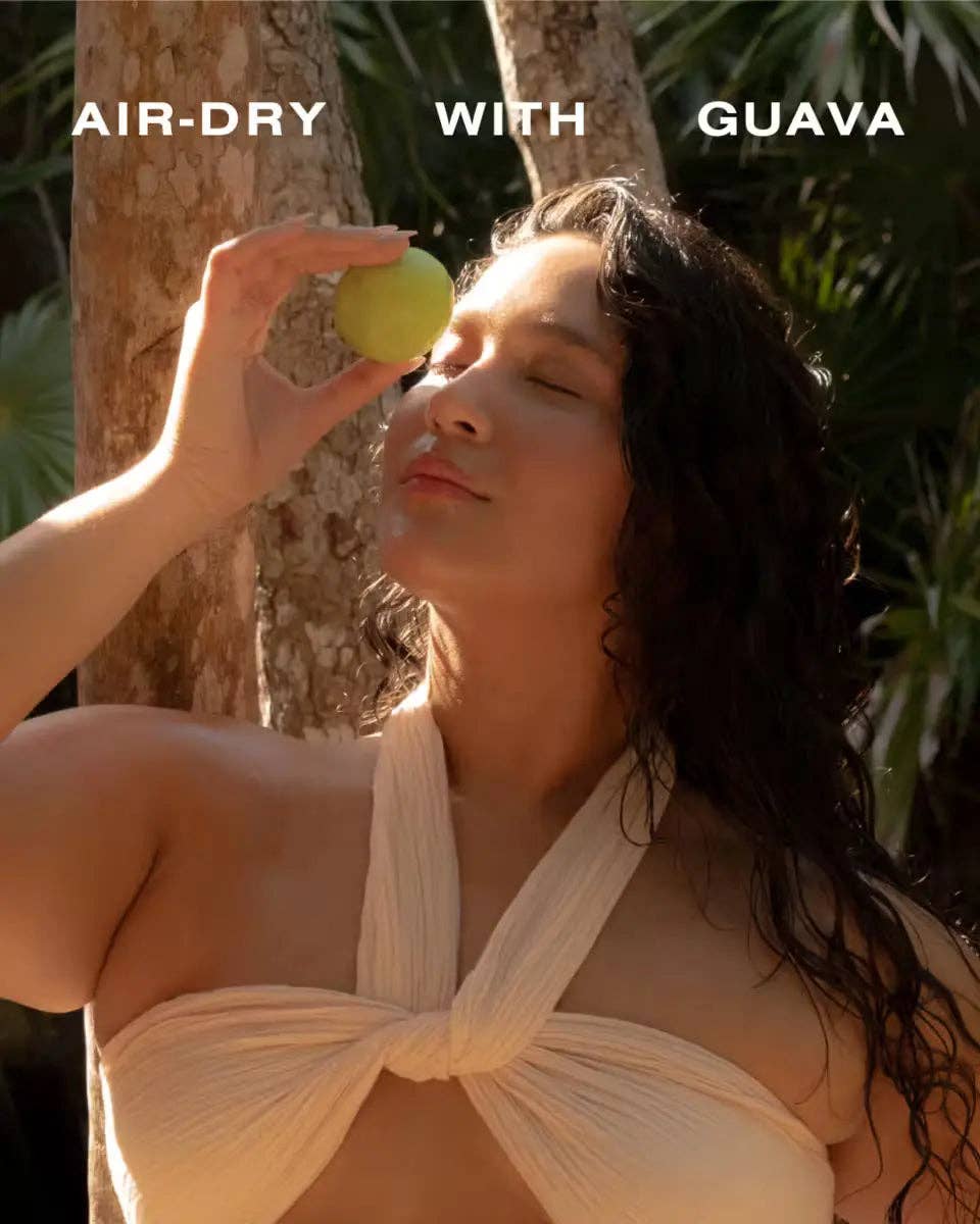 Woman holding a guava near her face with text 'AIR-DRY WITH GUAVA' above.