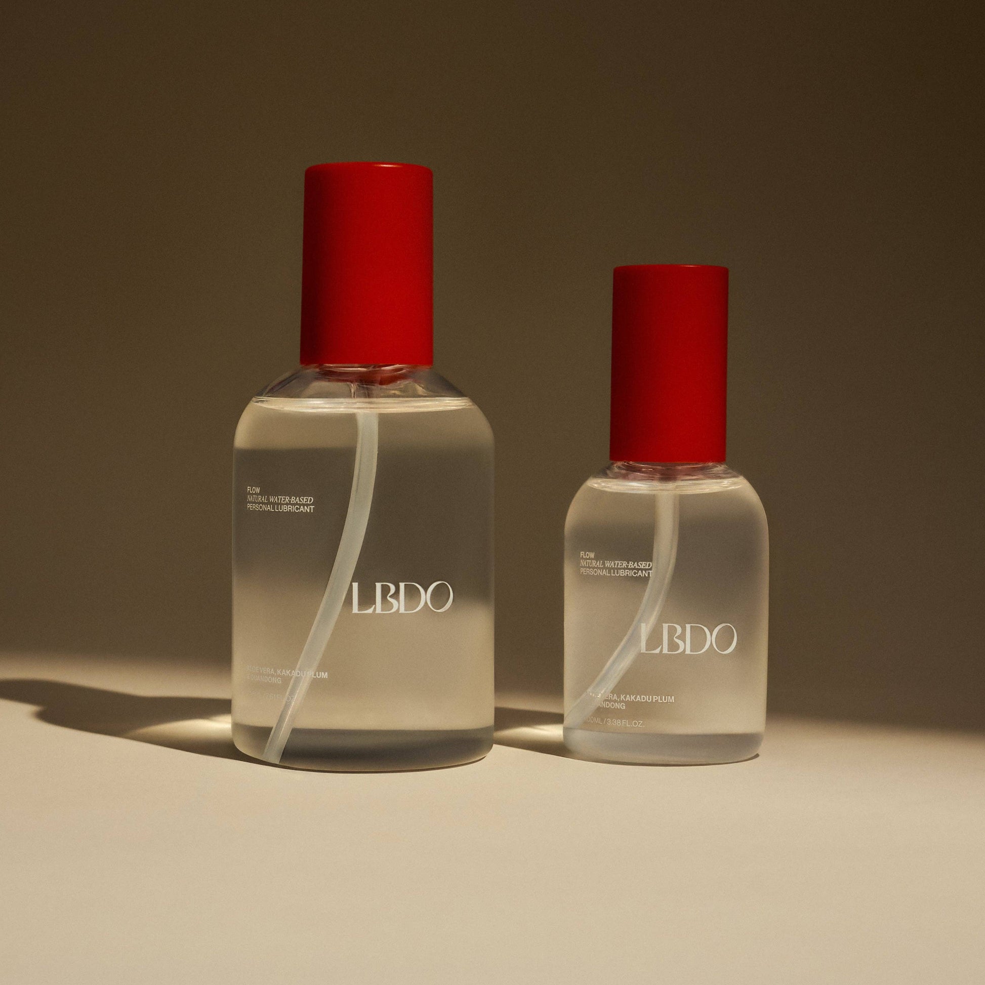 Two clear bottles with red caps labeled 'LBDO' on a beige background
