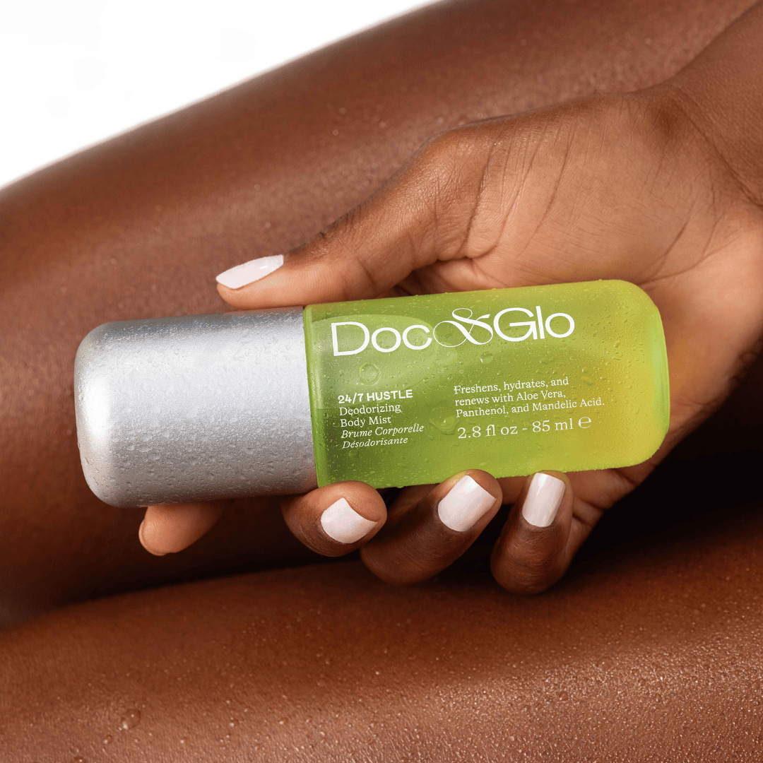 Hand holding a Doc Glo deodorant spray with a green label