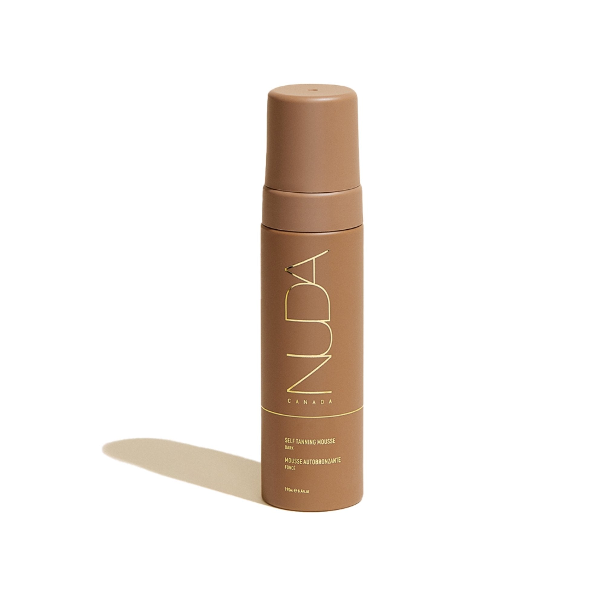 A pump bottle of Nuda self-tanning mousse against a white background