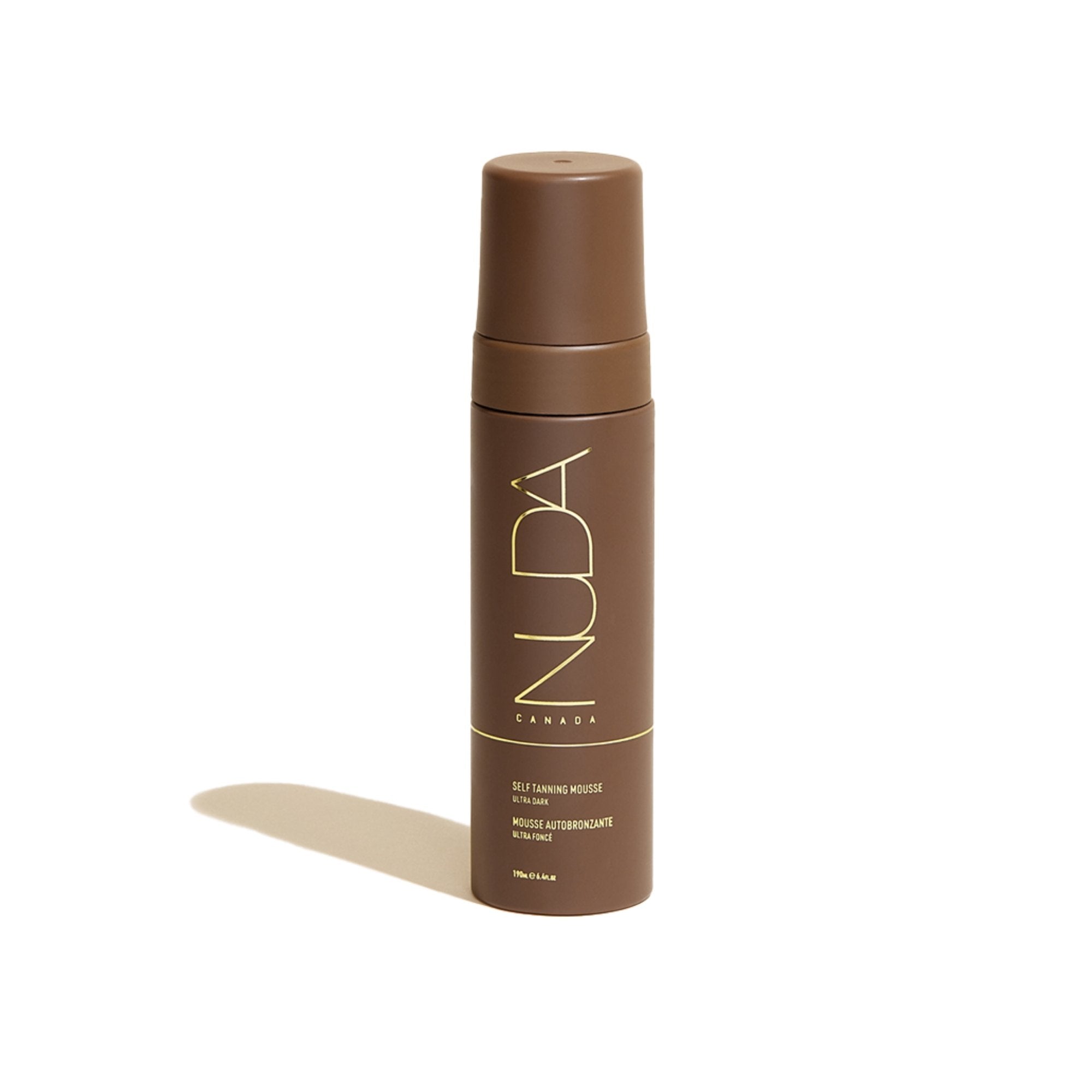 A brown NUDA mousse tanner bottle against a white background