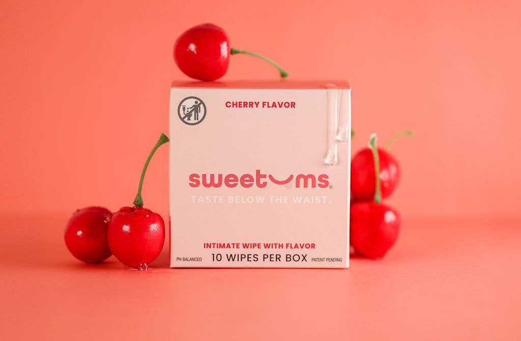 Box of 'sweetums' cherry-flavored intimate wipes with cherries on a pink background