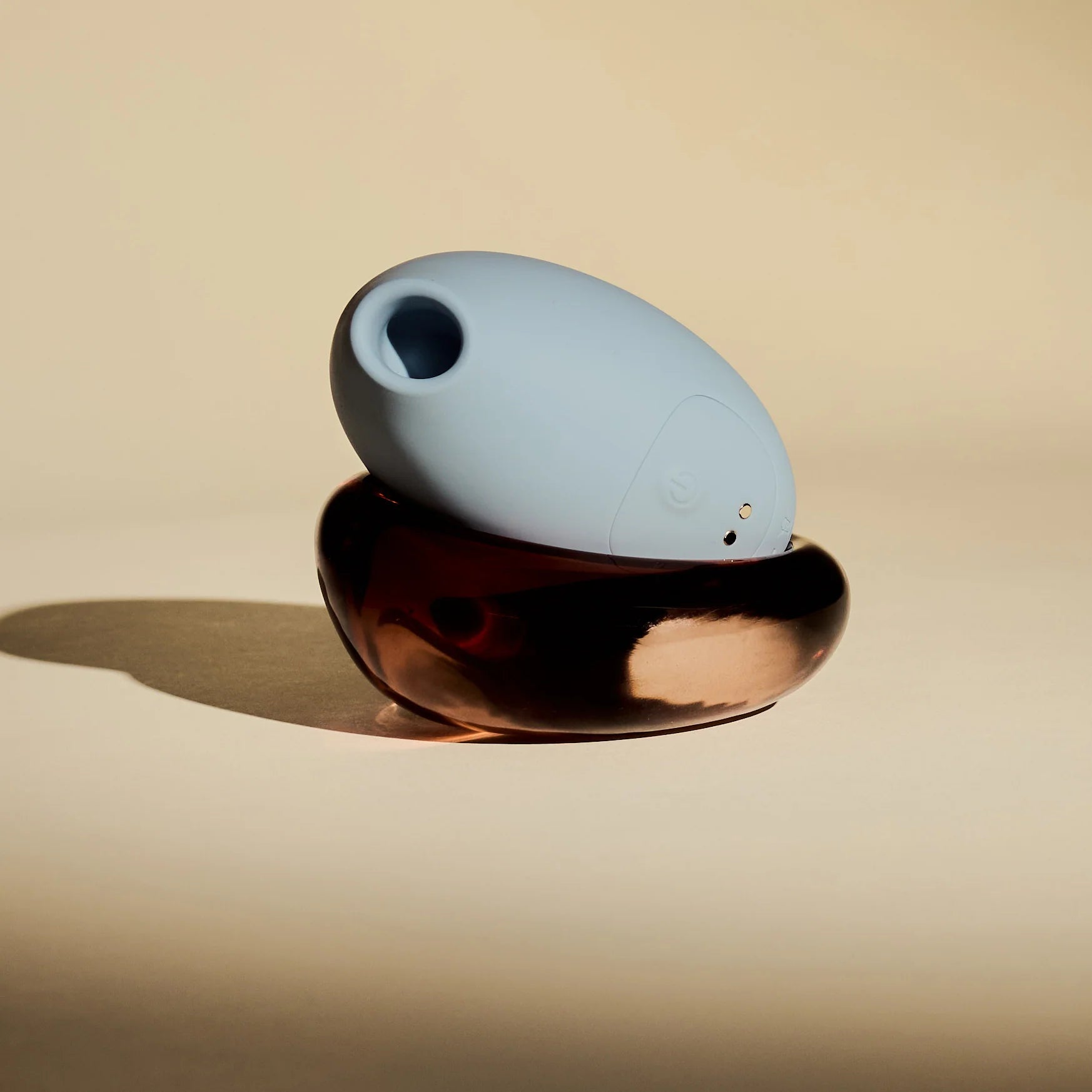 blue personal massager sitting atop a brown glass dish.