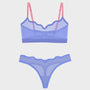 A two-piece sheer lingerie set featuring a lavender-blue mesh bralette with pink straps and matching high-waisted thong bottoms, shown on a light gray background.