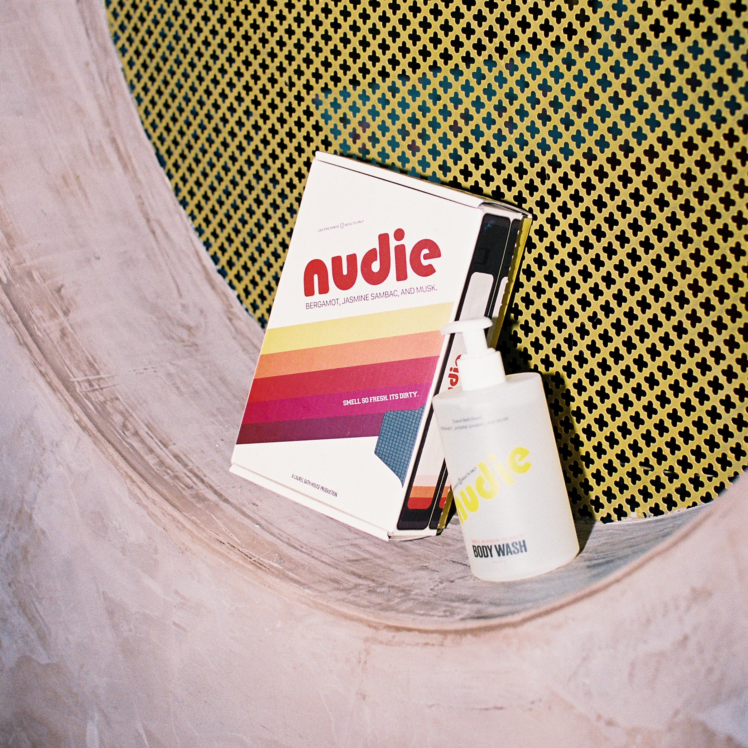Nudie bodywash on a shelf with a yellow textured backgournd