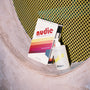 Nudie bodywash on a shelf with a yellow textured backgournd