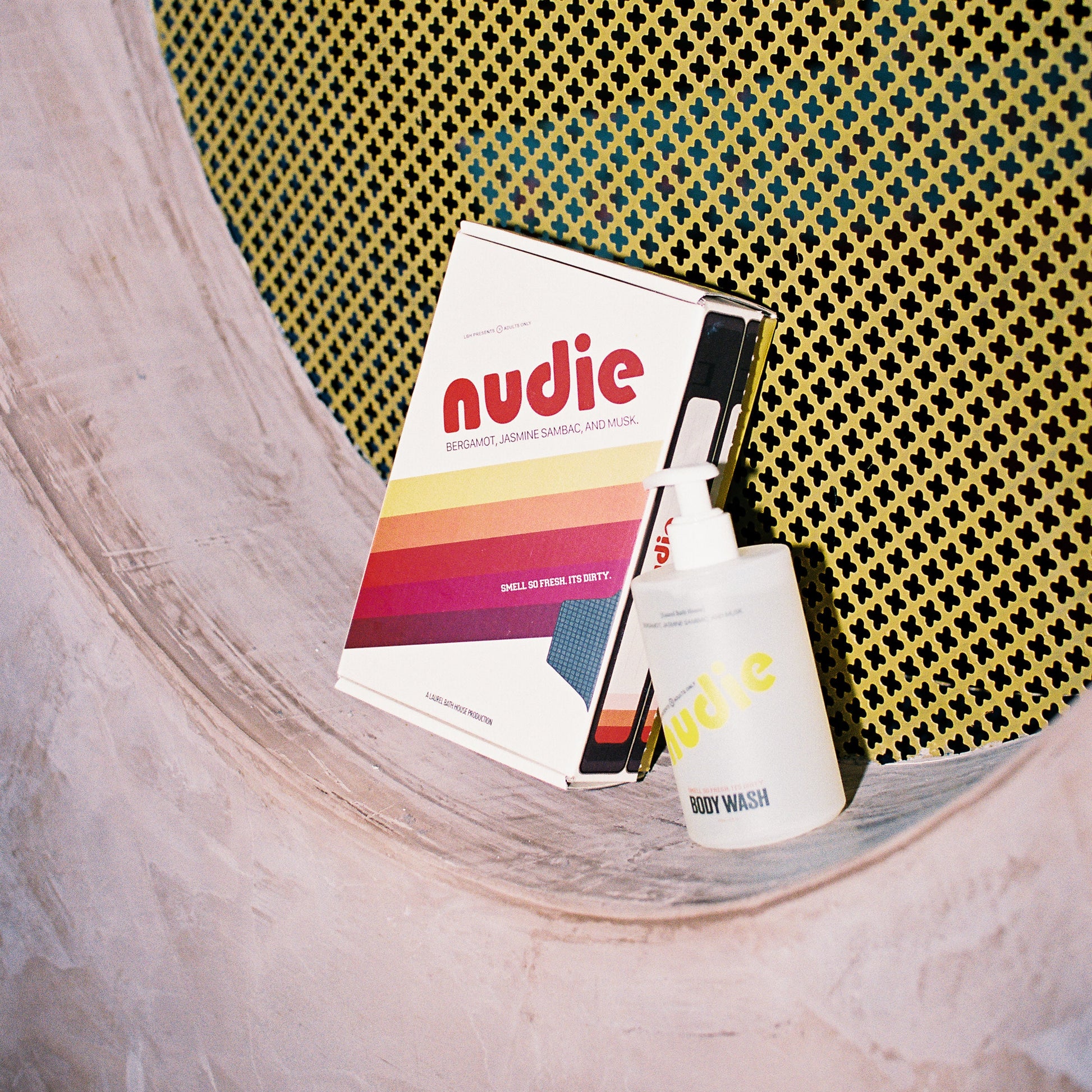 Nudie bodywash on a shelf with a yellow textured backgournd