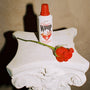 classic whip sunscreen on a pedestal with a rose against a beige background