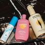 Three bottles of skincare products on a decorative tray with a dark background