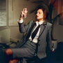 Woman in a suit sitting in an office with a plant in the background