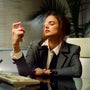 Woman in a professional setting using a spray bottle, possibly in an office.