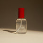 Clear bottle with red cap on a beige surface and brown background