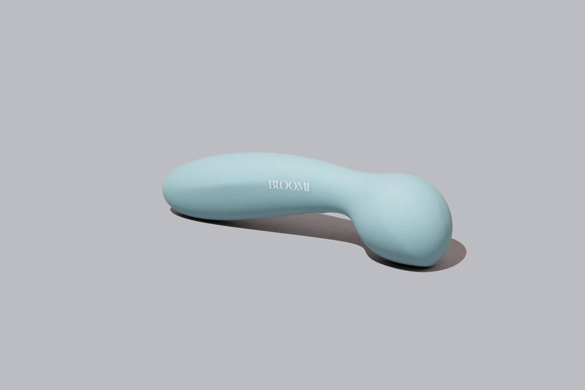 Light blue handheld massager with 'Bloom' branding on a gray background