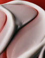 Close-up of a pink and white color swatch on a red background