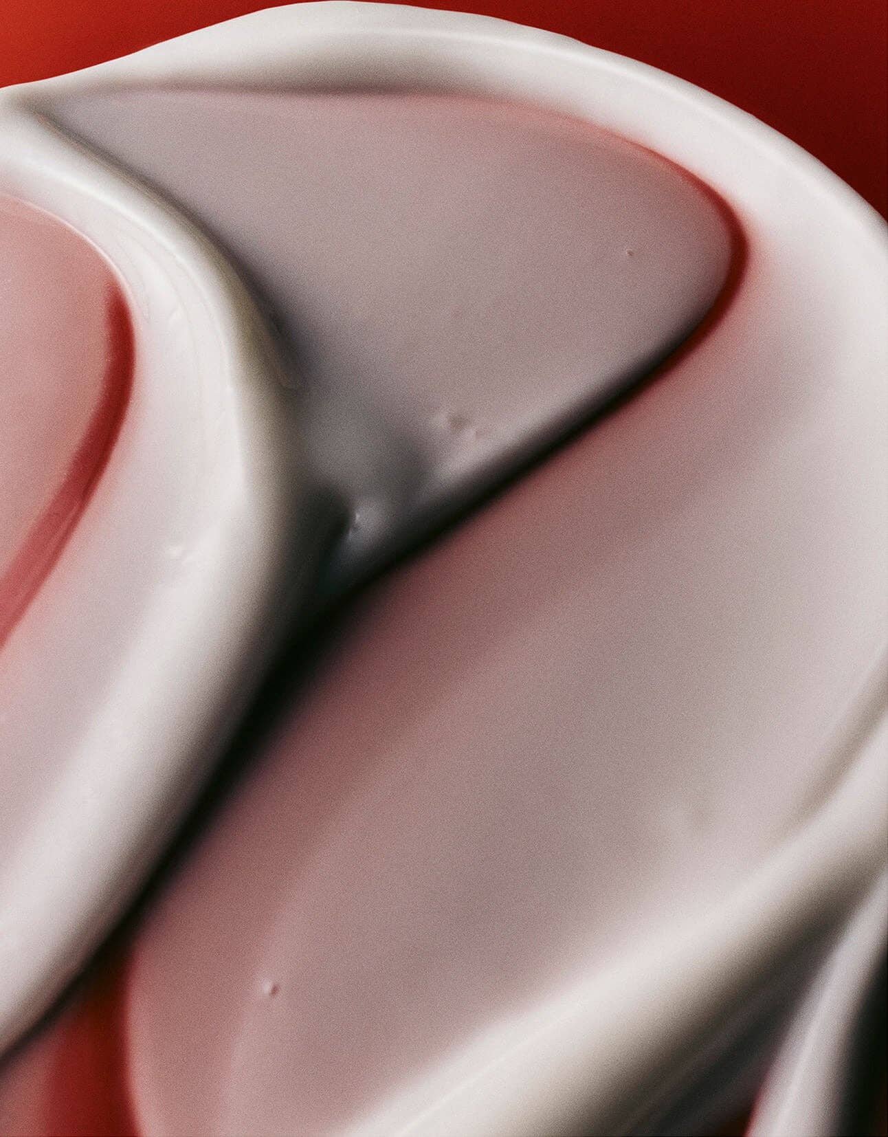 Close-up of a pink and white color swatch on a red background