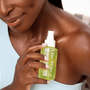 Person applying a green bottle labeled 'DocGlo' to their shoulder.