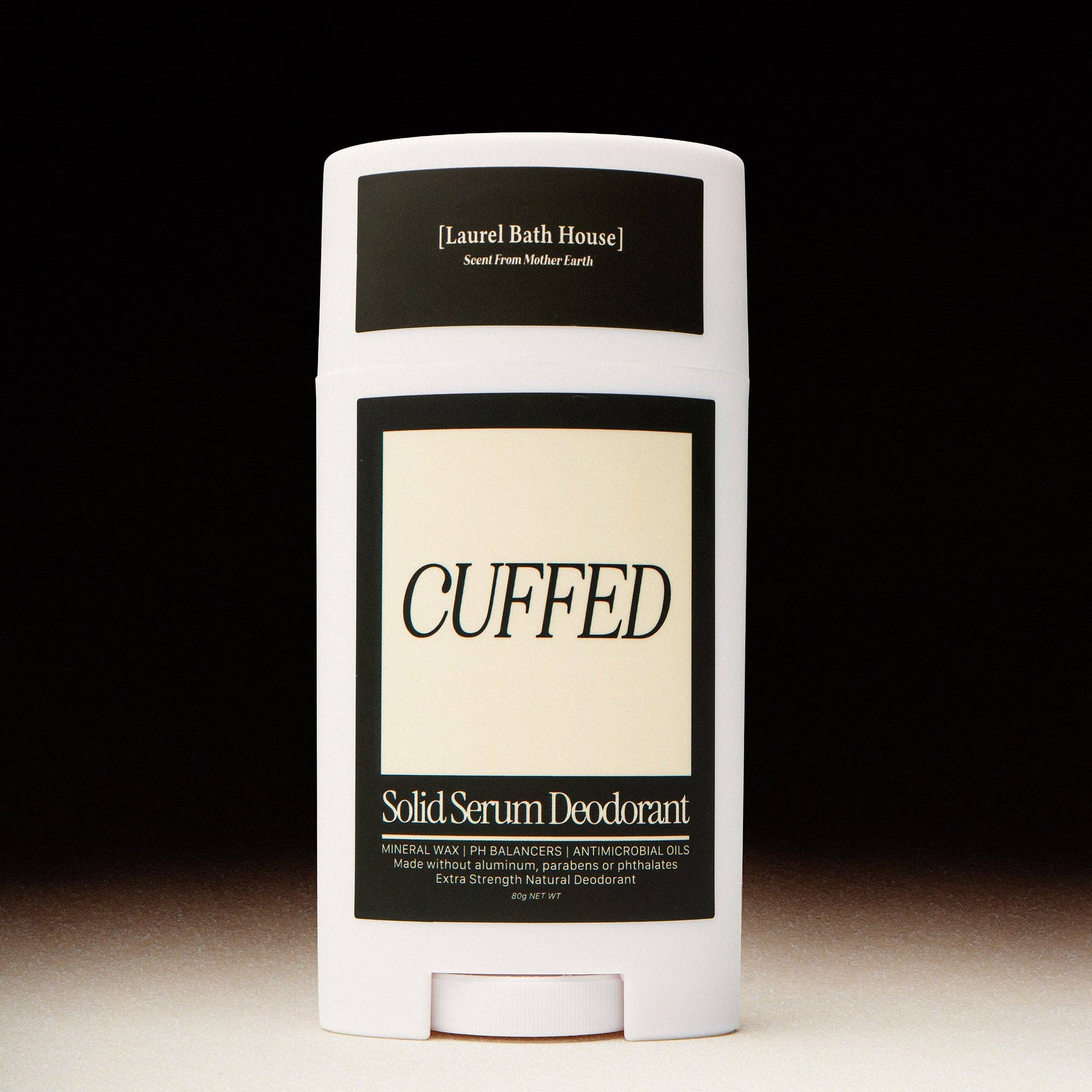 Solid serum deodorant stick with 'Cuffed' branding on a black background