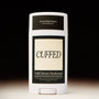 Solid serum deodorant stick with 'Cuffed' branding on a black background