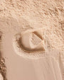 Close-up of a sandstone wall with a circular recess and square frame.
