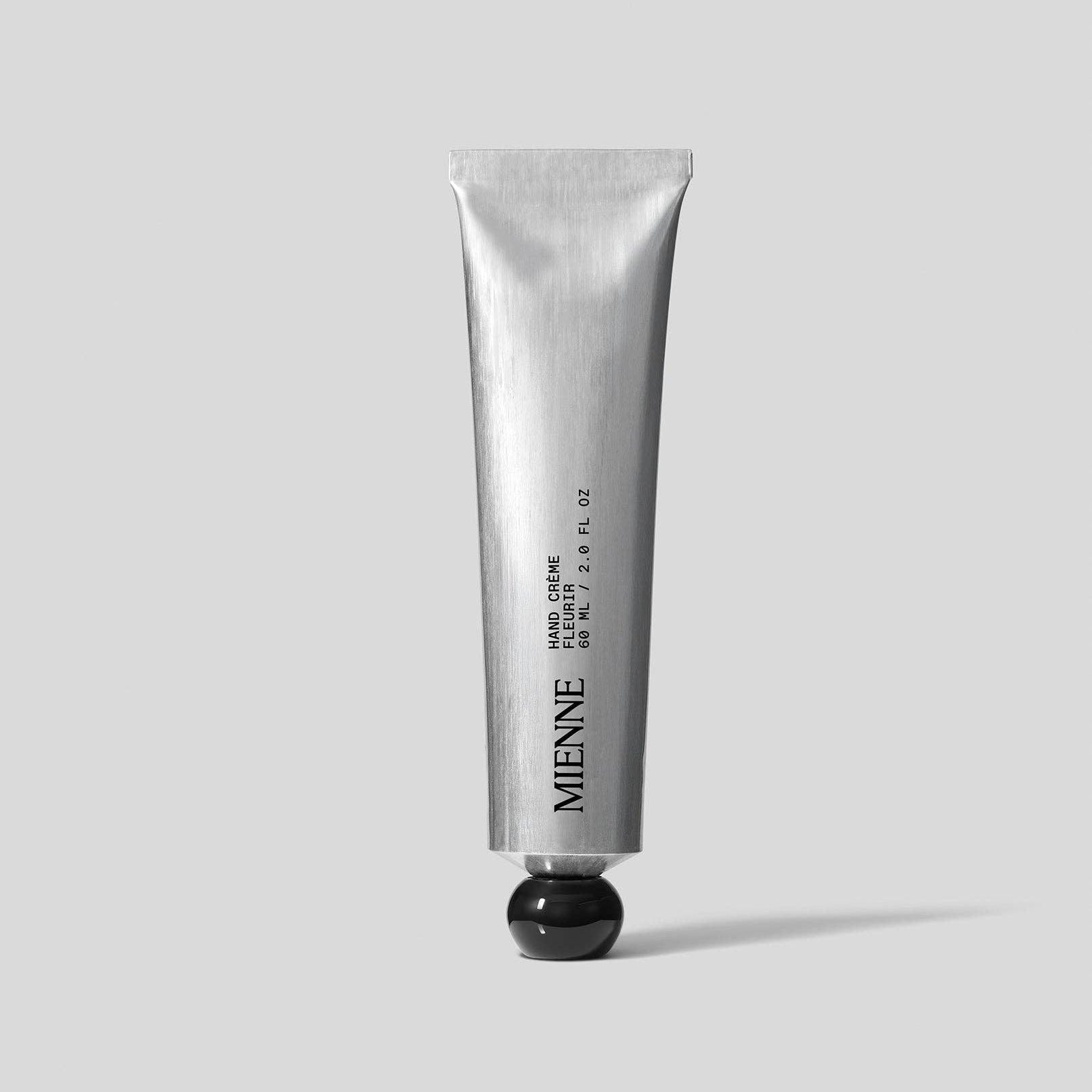 Silver tube of Mienie hand cream on a light gray background