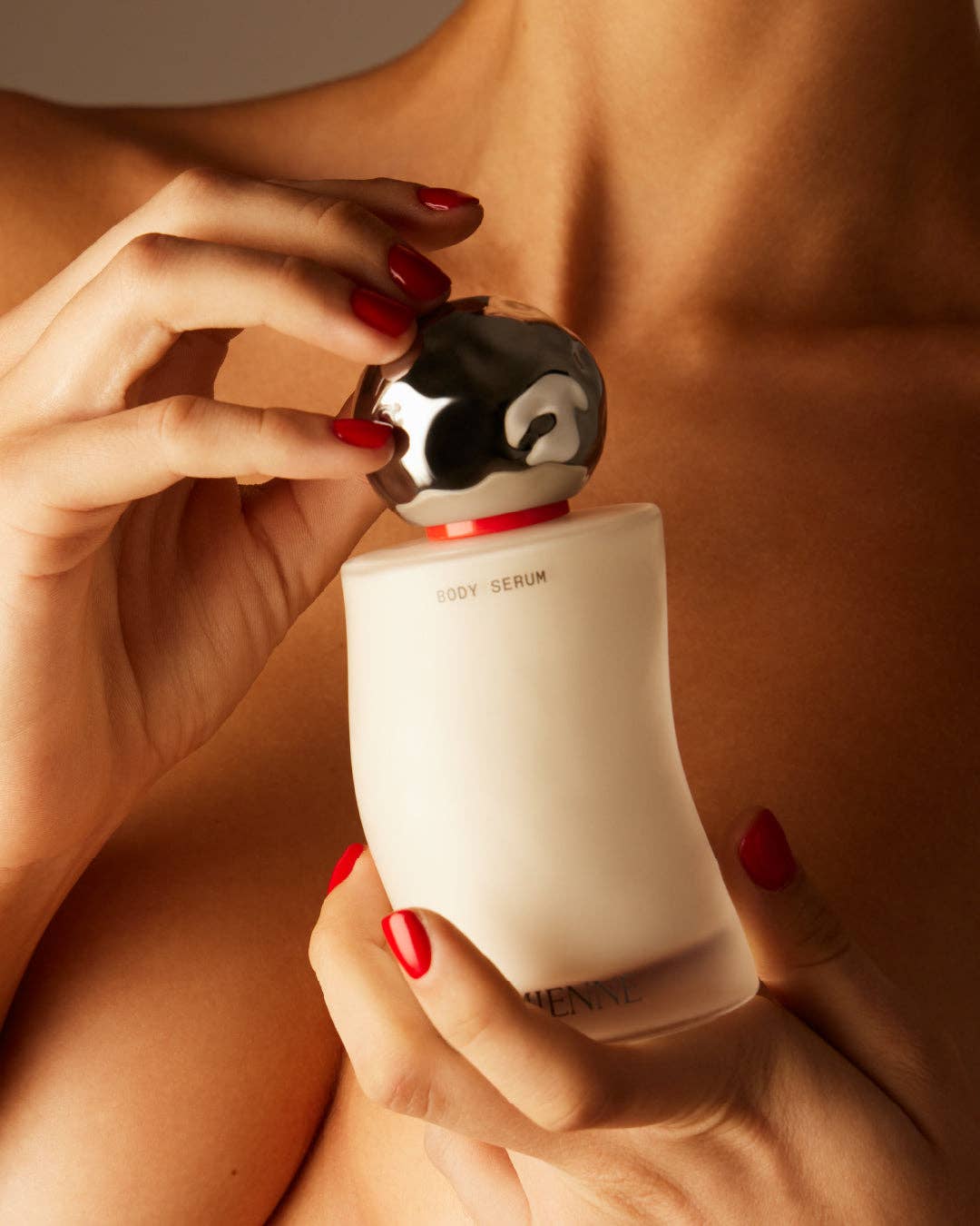 Person holding a skincare bottle with a close-up of the product.