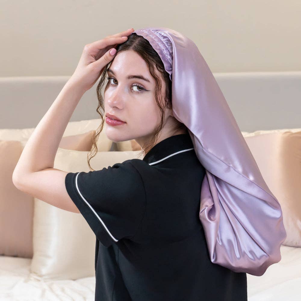 Woman wearing a satin bonnett in a bedroom setting