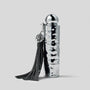 Silver textured bottle with black tassel on a light gray background